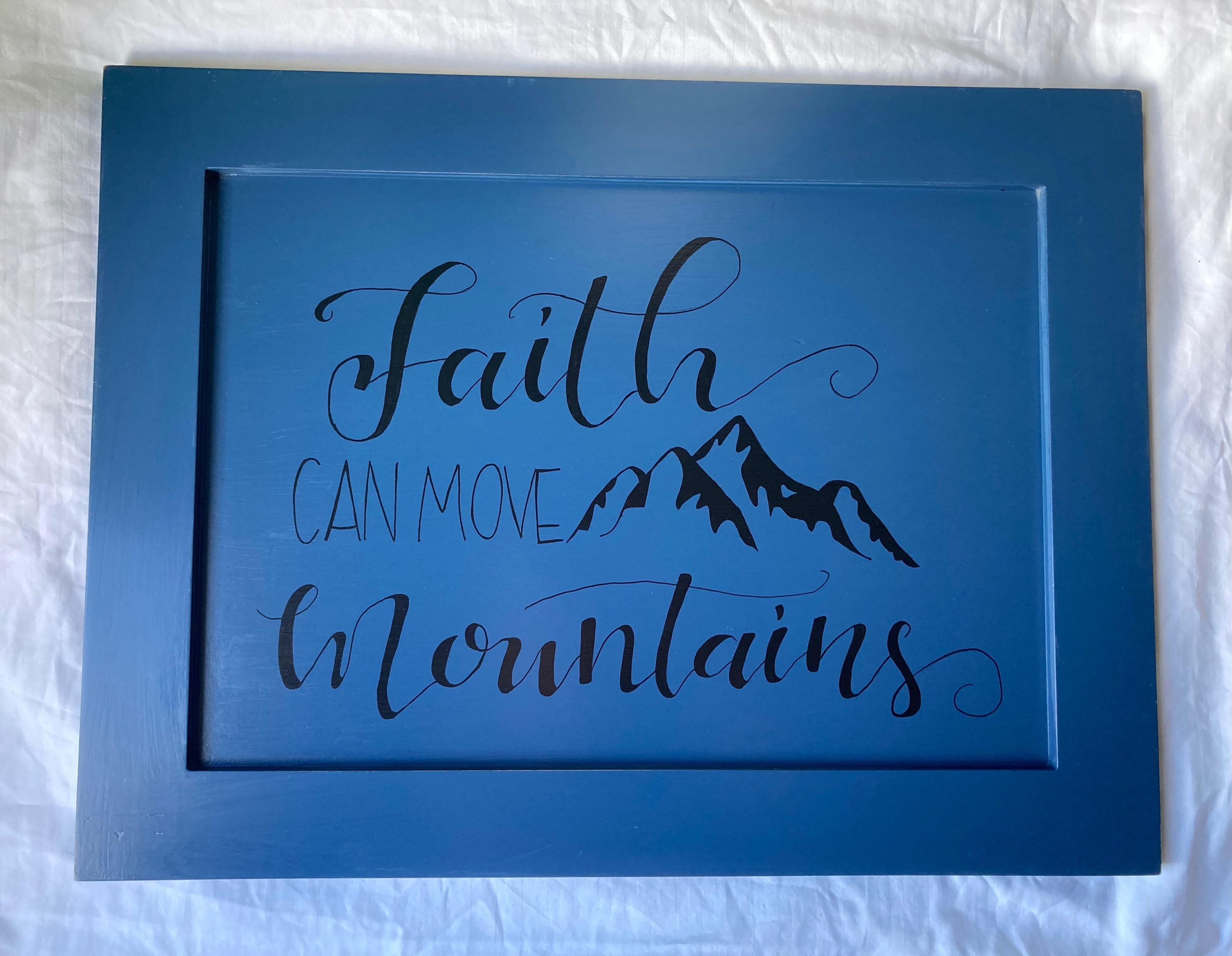 Faith can move mountains, painted blue sign